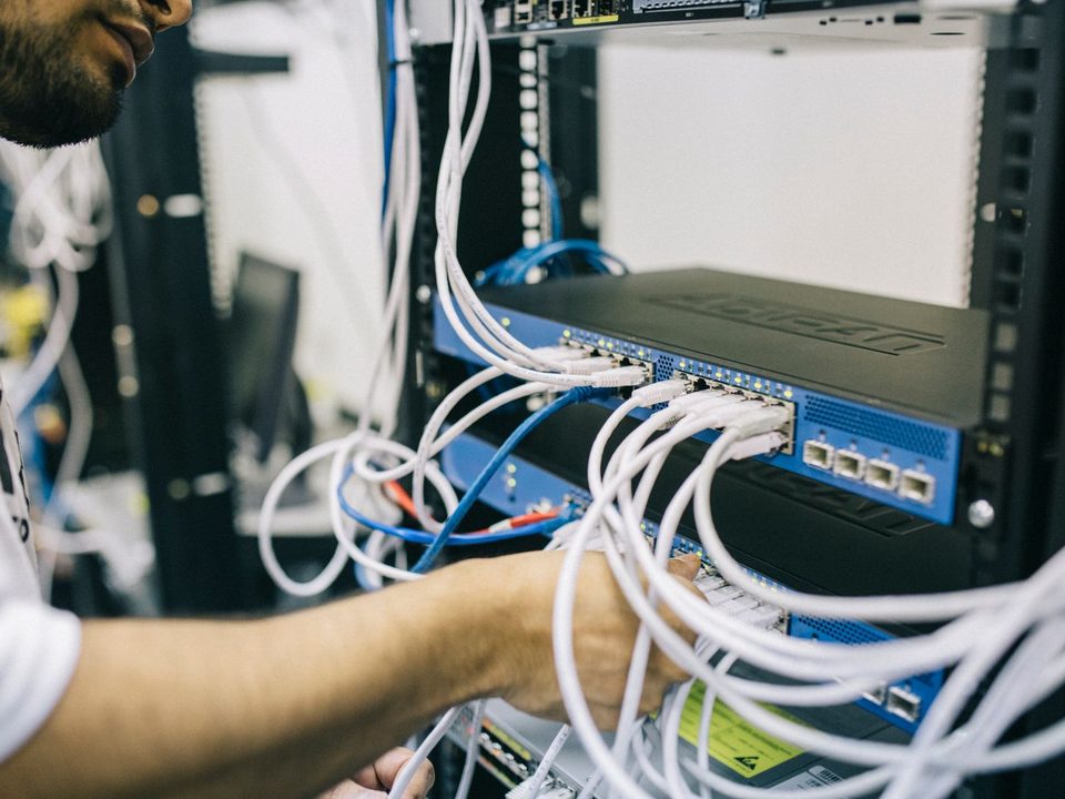 Technician patching cables into a network switch